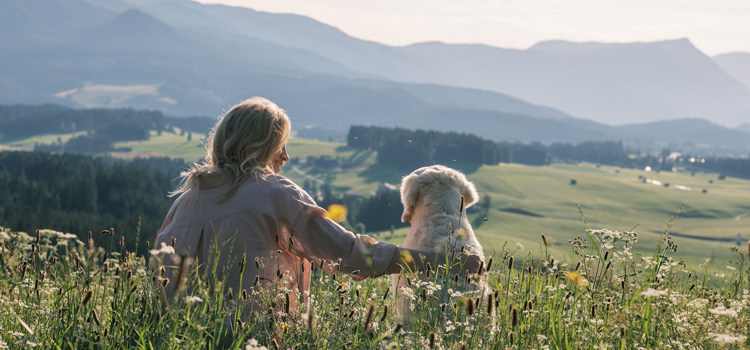 Katharina et Nala sont assises dans un pré et regardent la colline.